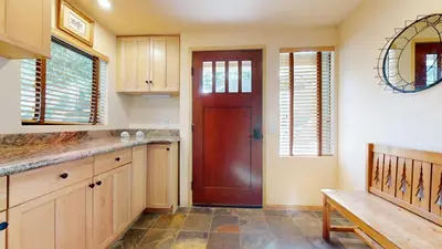 a kitchen with a red door and a wooden bench at Mammoth Sierra Townhomes #18 condo in Mammoth Lakes