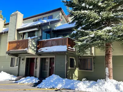 a house with snow on the ground in front of it at Mammoth Sierra Townhomes #18 condo in Mammoth Lakes