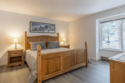 a bedroom with a wooden bed and a window at Horizons IV 180 New Luxurious Listing Fully Remodeled 2 Bedrm Plus Loft 2 and a half Bathrm Sleeps 8 in Mammoth Lakes
