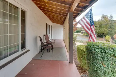 a porch with an american flag and two chairs at Game Room and Patio Charming Jackson Retreat! in Jackson