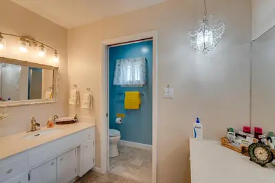 a bathroom with a sink and a toilet and a chandelier at Game Room and Patio Charming Jackson Retreat! in Jackson