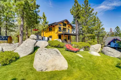a yellow house with a red chair in the yard at 4 Mi to Slopes! Hot Tub Haven with Lake Tahoe Views in Incline Village