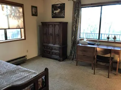 a bedroom with a desk and a bed and a window at Foothill Acres in Midpines