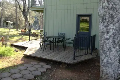 a porch with a table and chairs on a house at Foothill Acres in Midpines
