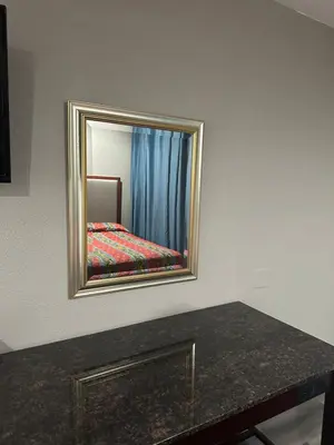 a mirror on a wall with a bed in a room at ROYAL MOTEL TRACY in Tracy