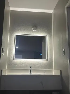 a mirror above a sink in a bathroom at ROYAL MOTEL TRACY in Tracy