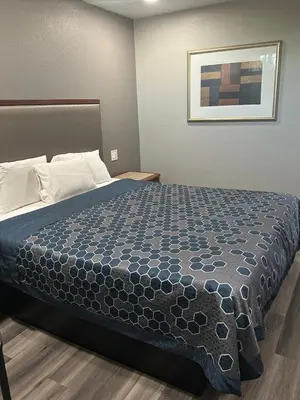 a bedroom with a bed with a blue comforter at ROYAL MOTEL TRACY in Tracy