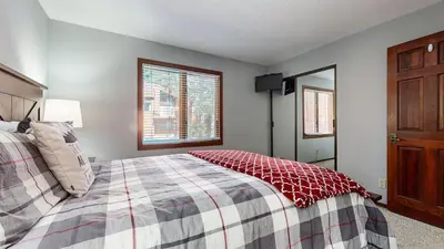 a bedroom with a bed and a window and a mirror at Woodlands #11 condo in Mammoth Lakes