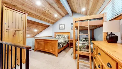a bedroom with a bunk bed and a bunk bed ladder at Woodlands #11 condo in Mammoth Lakes