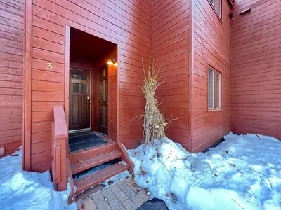 a red house with snow on the side of it at Winterset #3 condo in Mammoth Lakes