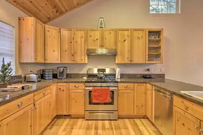 a kitchen with wooden cabinets and a stove top oven at Cold Springs Mountain Cabin Hot Tub and Generator in Cold Springs