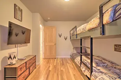 a bedroom with two bunk beds and a flat screen tv at Cold Springs Mountain Cabin Hot Tub and Generator in Cold Springs