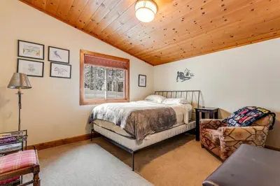 a bedroom with a bed and a chair at Cabin in Soda Springs in Soda Springs