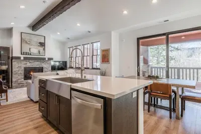 a kitchen and living room with a fireplace at Creekhouse 1553 in Mammoth Lakes