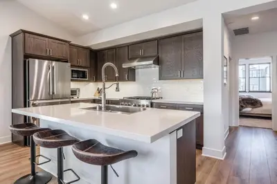 a kitchen with wooden cabinets and a large island with bar stools at Creekhouse 1553 in Mammoth Lakes