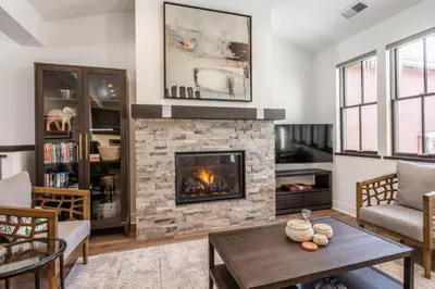 a living room with a fireplace and a table at Creekhouse 1553 in Mammoth Lakes