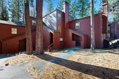 a red house with trees in front of it at Golf Club Condos #437 in Truckee