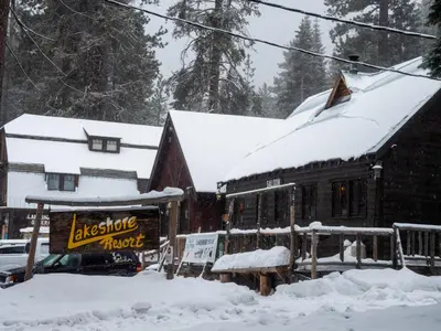a snow covered building with a sign in front of it at Lakeshore Resort in Lakeshore