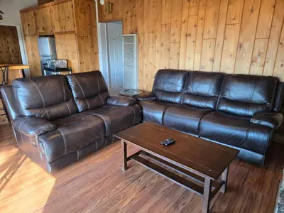 a leather couch and a coffee table in a living room at Panoramic Lake View, Lake Isabella in Wofford Heights