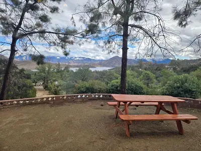 a wooden picnic table sitting on top of a field at Panoramic Lake View, Lake Isabella in Wofford Heights