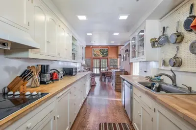 a kitchen with white cabinets and a wooden floor at Walk to the Lake - Ski in out Amazing 5 Bdrm - VH#343 in Bear Valley