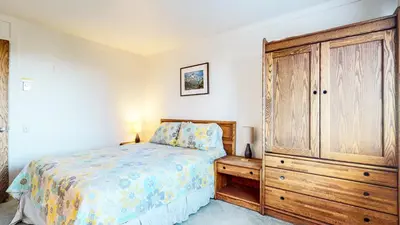 a bedroom with a bed and a wooden cabinet at Mammoth Point #106 condo in Mammoth Lakes