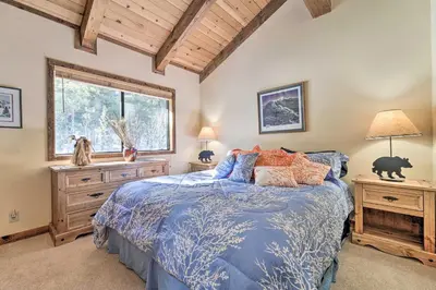 a bedroom with a blue bed and a window at Shuttle to Ski Resort Northstar Home! in Truckee
