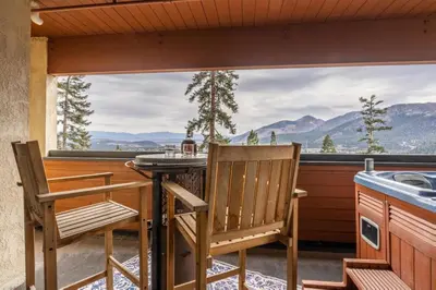 a balcony with a table and chairs and a view of mountains at Bridges 112 in Mammoth Lakes