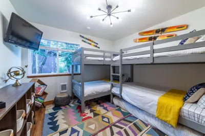 a bedroom with two bunk beds and a television at Mammoth Estates 210 in Mammoth Lakes