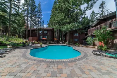 a swimming pool in a patio with chairs around it at Mammoth Estates 210 in Mammoth Lakes