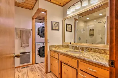 a bathroom with a sink and a washer and dryer at Deck with Forest Views Quiet Twain Harte Cabin! in Twain Harte