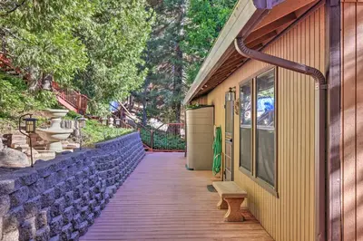 a wooden walkway with a bench next to a building at Deck with Forest Views Quiet Twain Harte Cabin! in Twain Harte