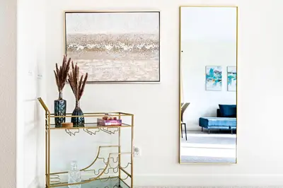a living room with a gold console table and a mirror at Stylish 4BR Home Nr Golden Eagle Sports Complex in Sparks