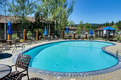 a swimming pool at a hotel with chairs and umbrellas at Lake Forest Drive Retreat in Tahoe City