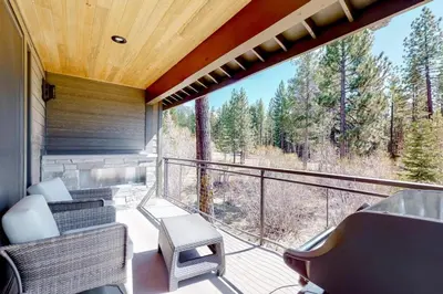 a balcony with chairs and a view of the woods at Gondola Vista Luxury Villas by Ski Heavenly & Beaches in South Lake Tahoe