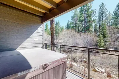 a balcony with a bed and a view of the woods at Gondola Vista Luxury Villas by Ski Heavenly & Beaches in South Lake Tahoe