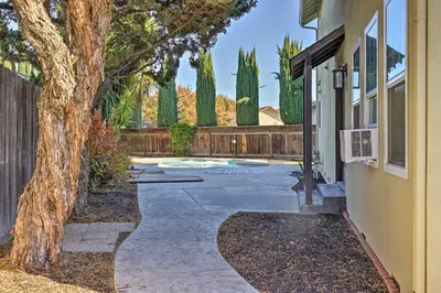 a walkway in front of a house with a tree at Modesto Home with Deck - 2 Mi to Vintage Faire Mall in Modesto