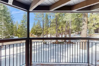 a screened porch with a view of the woods at Northstar's Cozy Condo in Truckee
