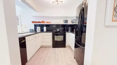 a kitchen with white cabinets and a black refrigerator at Walk to Canyon Lodge! Ski back! Modern Space in Mammoth Lakes