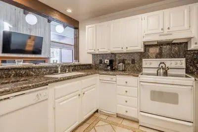 a kitchen with white cabinets and a sink at Mammoth Ski and Racquet 71 in Mammoth Lakes