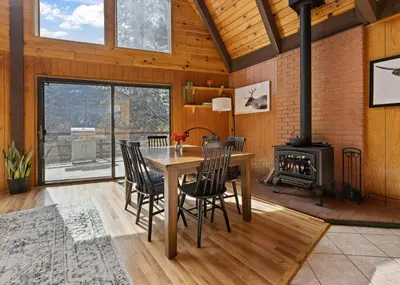 a dining room with a table and chairs and a stove at Hygge Haus Sequoia - Large Private Cabin w Views in Ponderosa