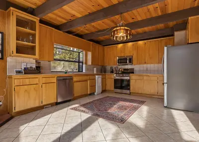 a kitchen with wooden cabinets and stainless steel appliances at Hygge Haus Sequoia - Large Private Cabin w Views in Ponderosa