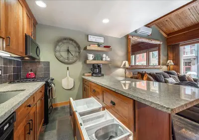 a kitchen with a large clock on the wall at Cozy Northstar Village Family Condo Walk to Lifts 2 Full BA Excellent Location in Truckee