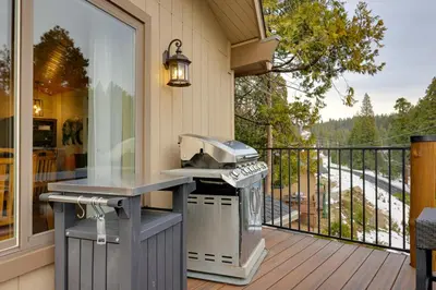 a outdoor kitchen with a grill on a deck at Hot Tub and Scenic Views Luxury Twain Harte Cabin! in Twain Harte