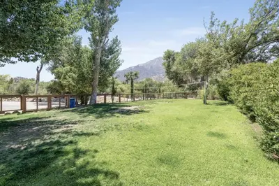 a large yard with trees and a fence at Quiet little pet friendly cabin in Kernville