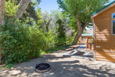 a patio with a picnic table next to a house at Adorable little cabin #26 in Kernville