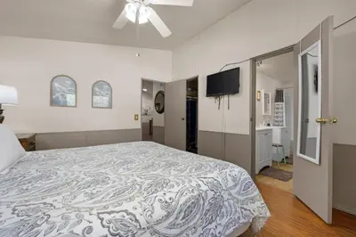 a bedroom with a large bed and a flat screen tv at The Sequoia House in Kernville