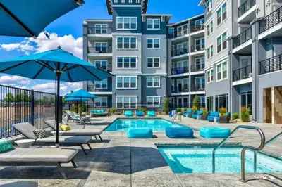 a pool with chairs and umbrellas in front of a building at Designer Apt w Jacuzzi Walk To Casino & iMax in Sparks