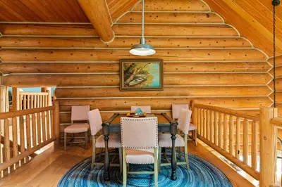 a dining room in a log cabin with a table and chairs at Willow Cove Log Cabin in Bass Lake
