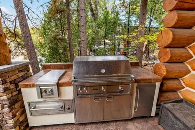 a grill and oven on a patio in a yard at Willow Cove Log Cabin in Bass Lake